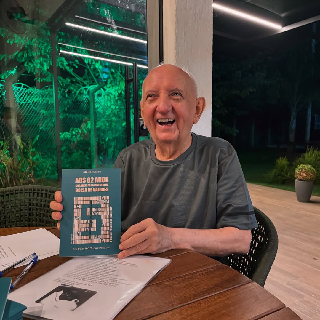 Foto de Alberto Garcia, sorrindo, segurando seu livro sobre investimentos.